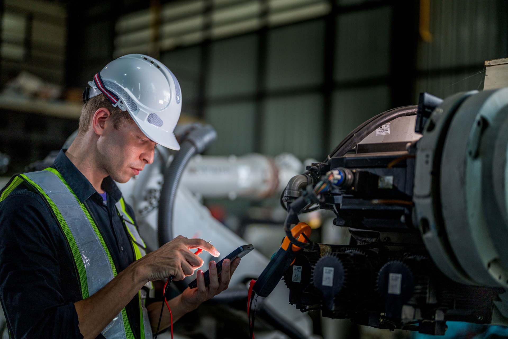 male engineer workers maintenance automatic robotic arm machine in a factory. worker checking and repairing automatic robot hand machine. technician worker check for repair factory machine.